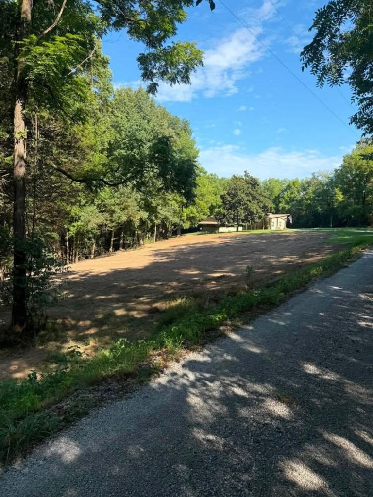Cleared and graded lot beside road — drainage prep by SAN Excavating