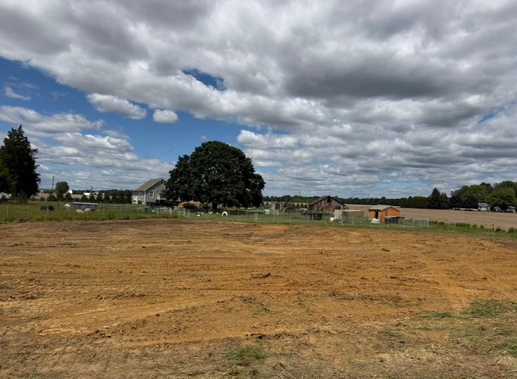 SAN Excavating graded field with farmhouse backdrop — South Jersey land clearing